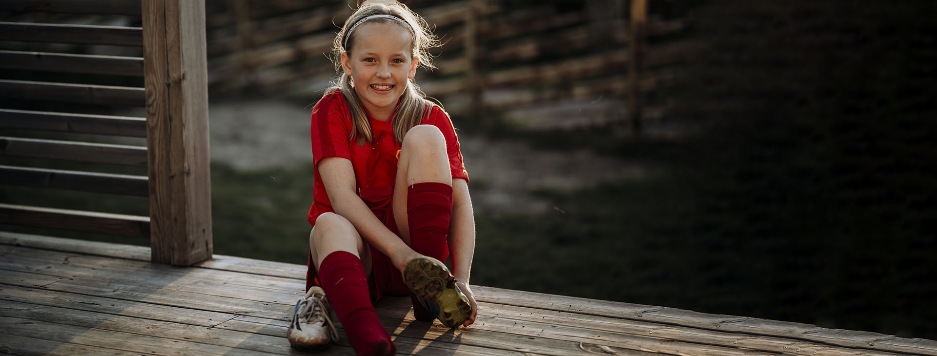 Barn som tar på sig fotbollsskor.