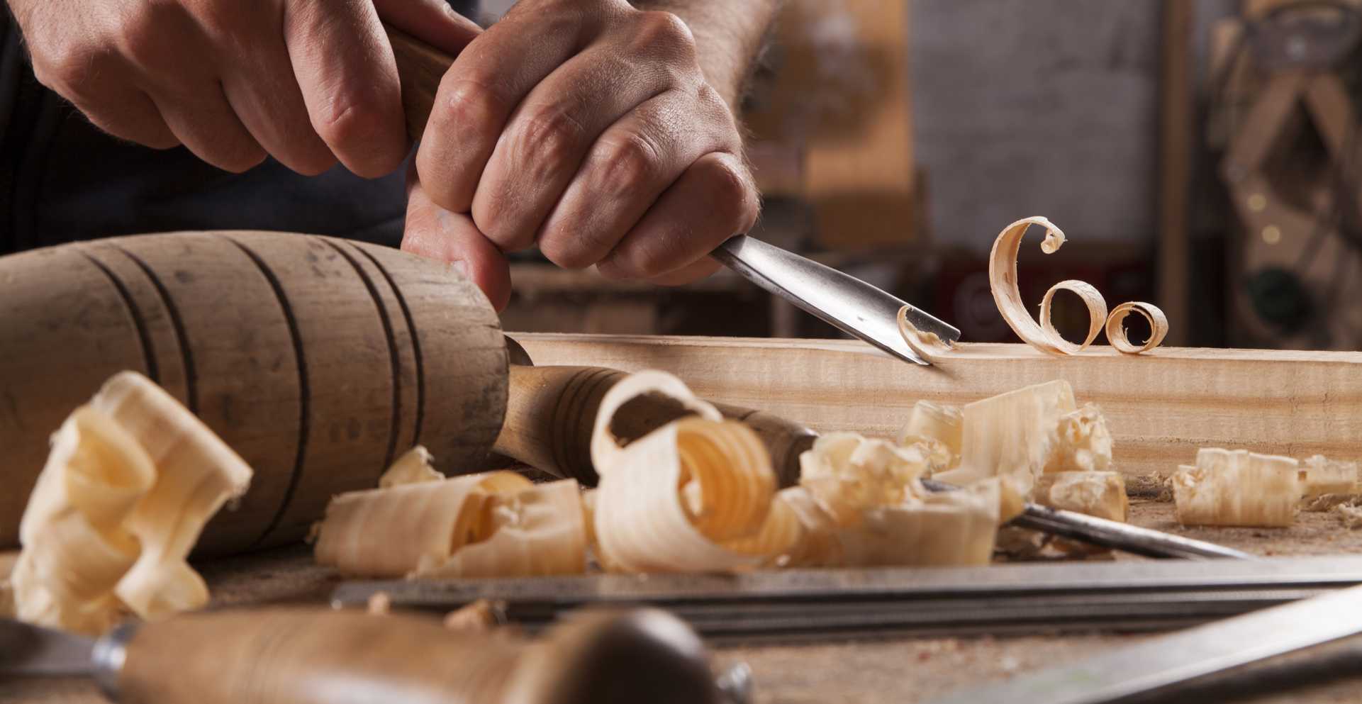 Bilden visar en person som karvar i trä.