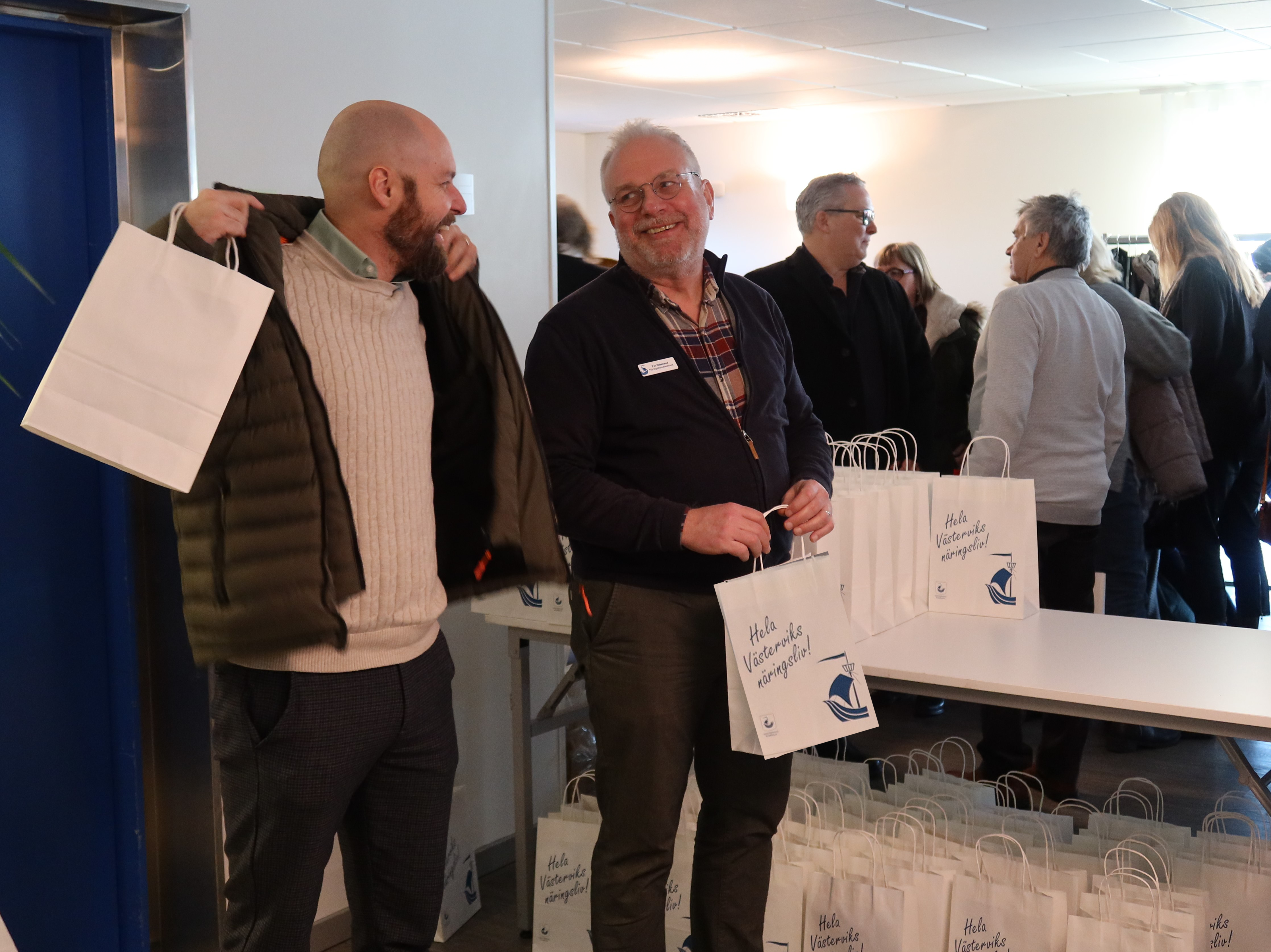 Två personer skrattar tillsammans under en näringslivsfrukost på Stadshotellet i Västervik