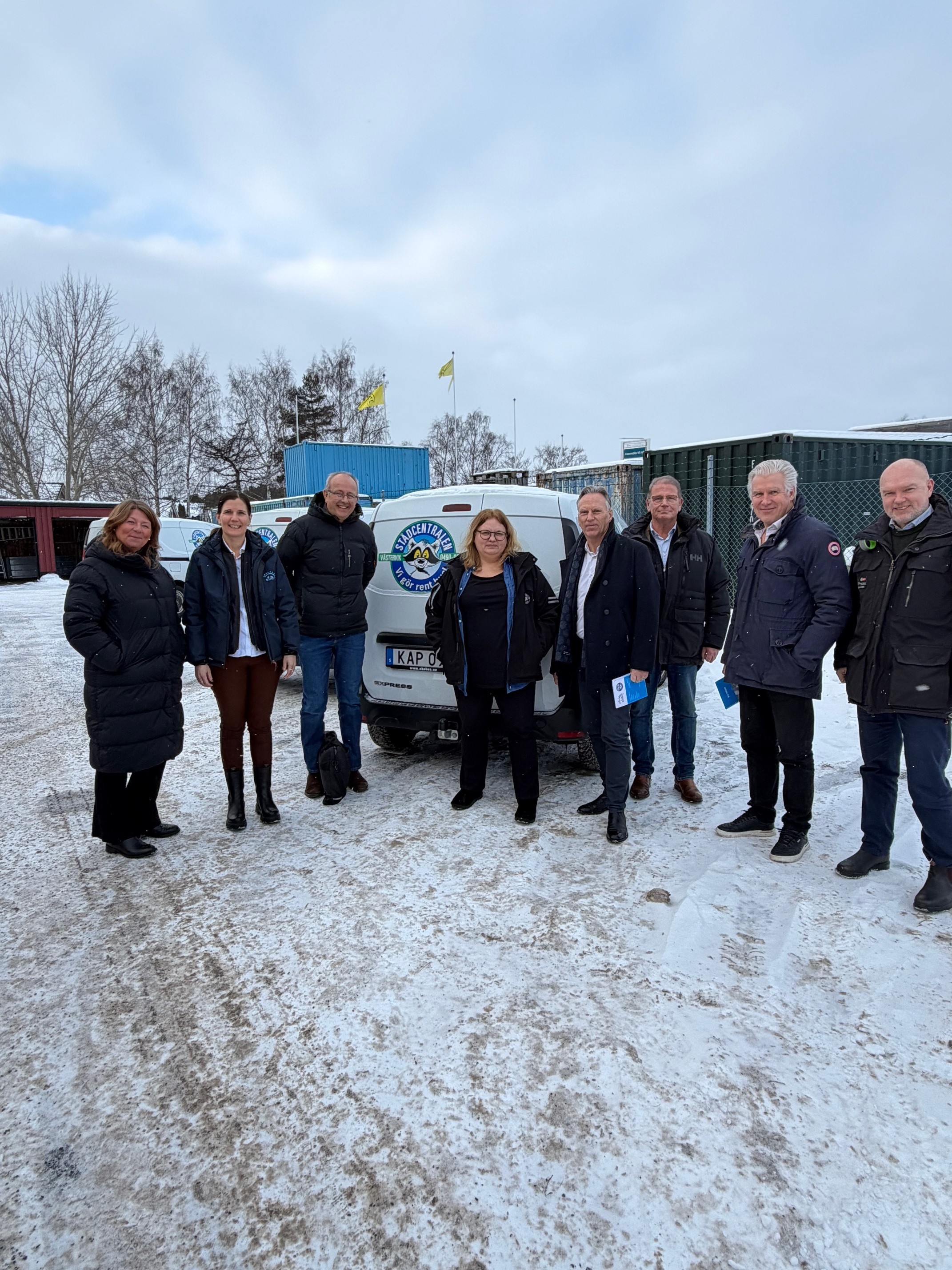 Medarbetare på Städcentralen framför en av deras bilar. 