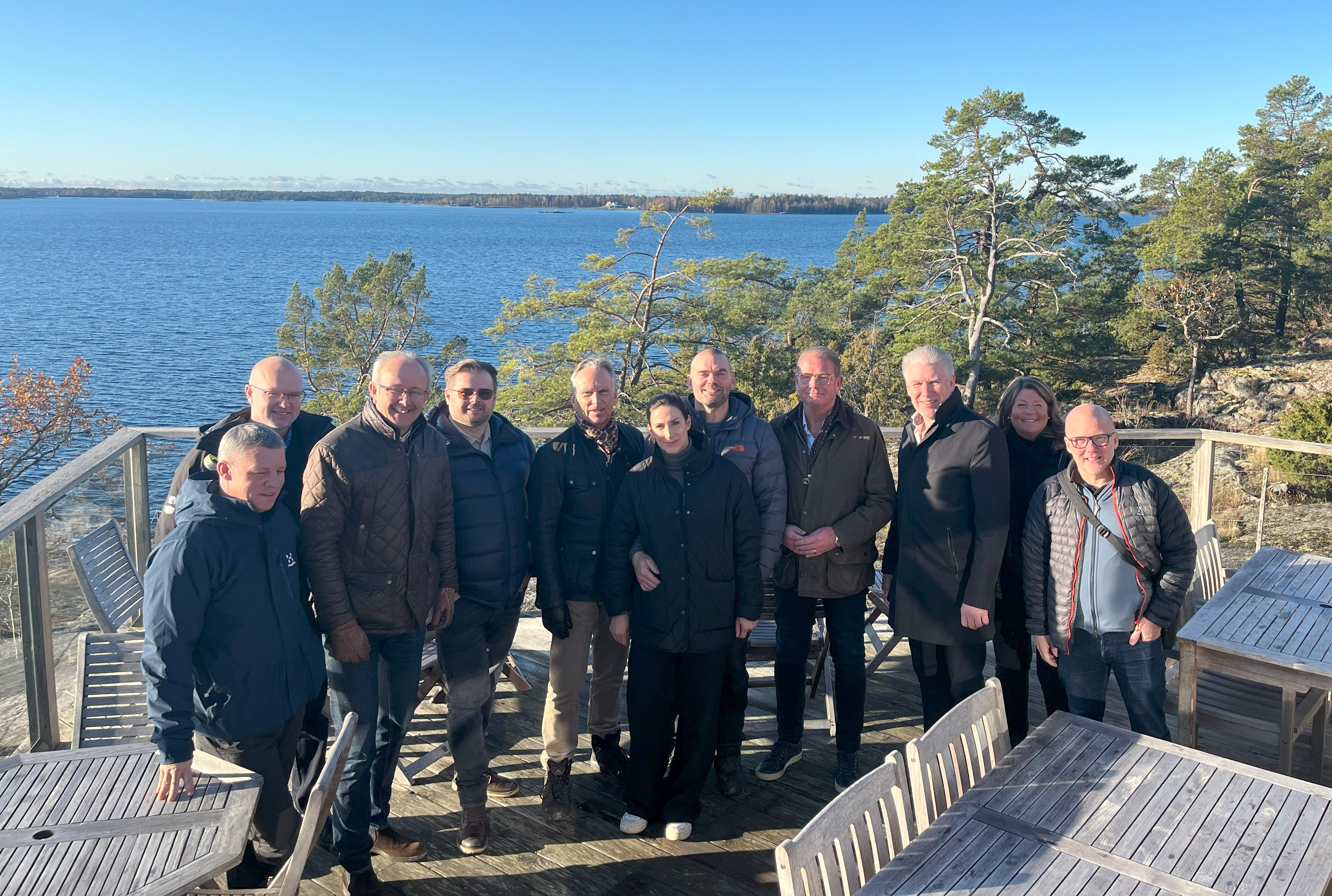 En grupp människor som står med havet som bakgrund. 