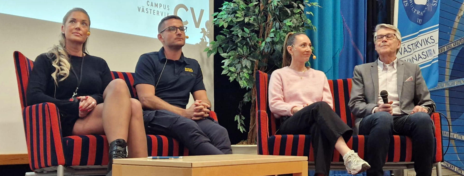 Fyra personer som sitter i ett panelsamtal på en scen.