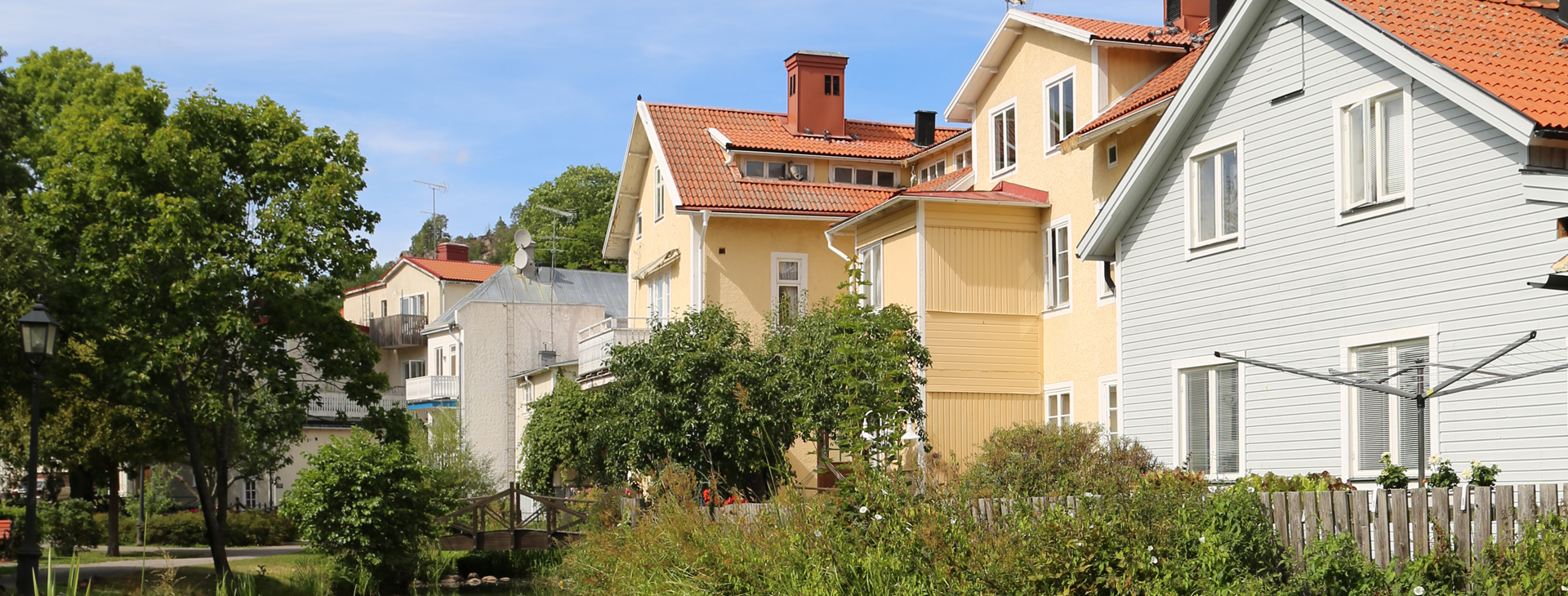 Kvinna målar rött hus.