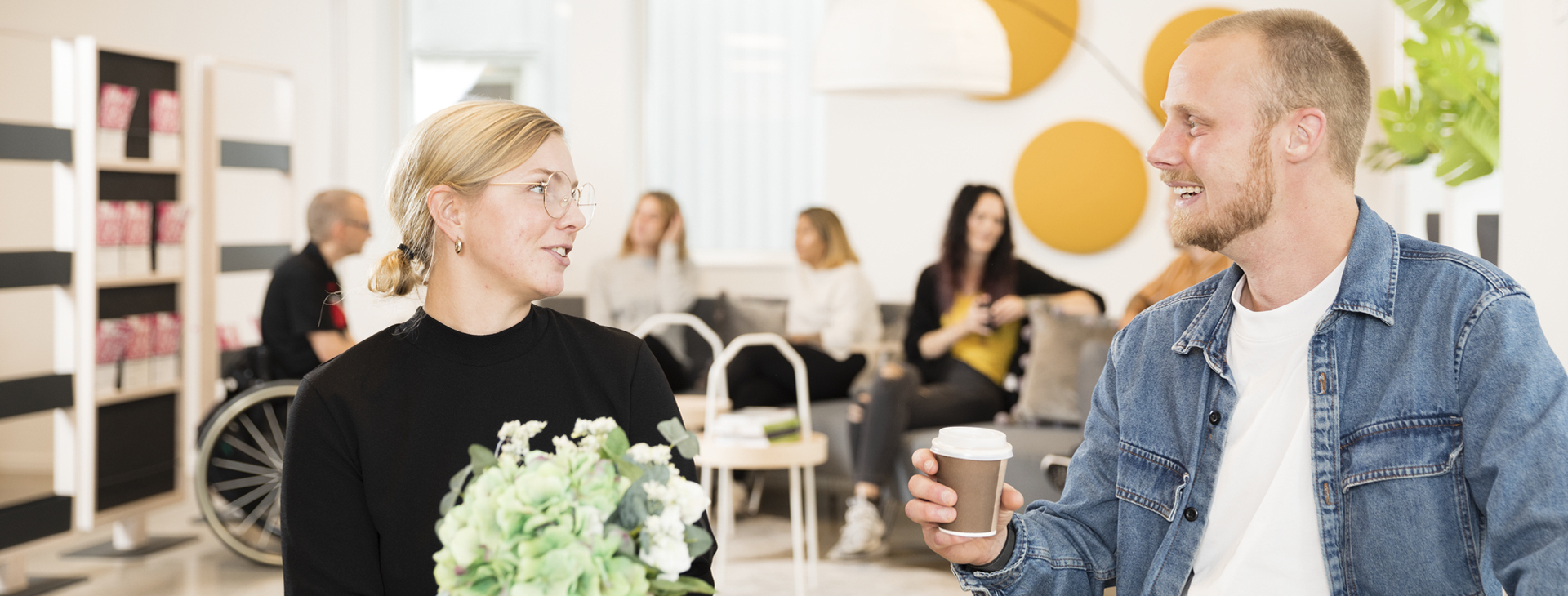 Två glada studenter som sitter vid ett bord och fikar.