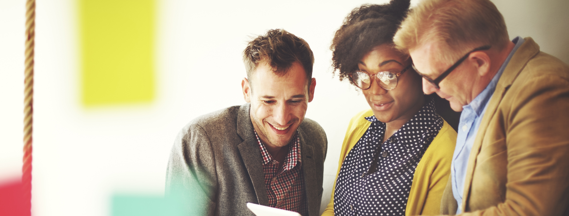 Tre personer som tillsammans tittar på ett informationsblad.