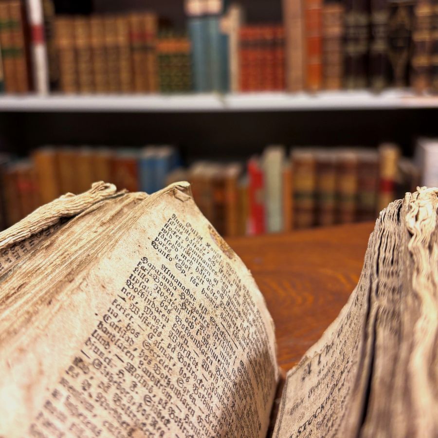 Gammal gulnad bok med böcker i bakgrunden.