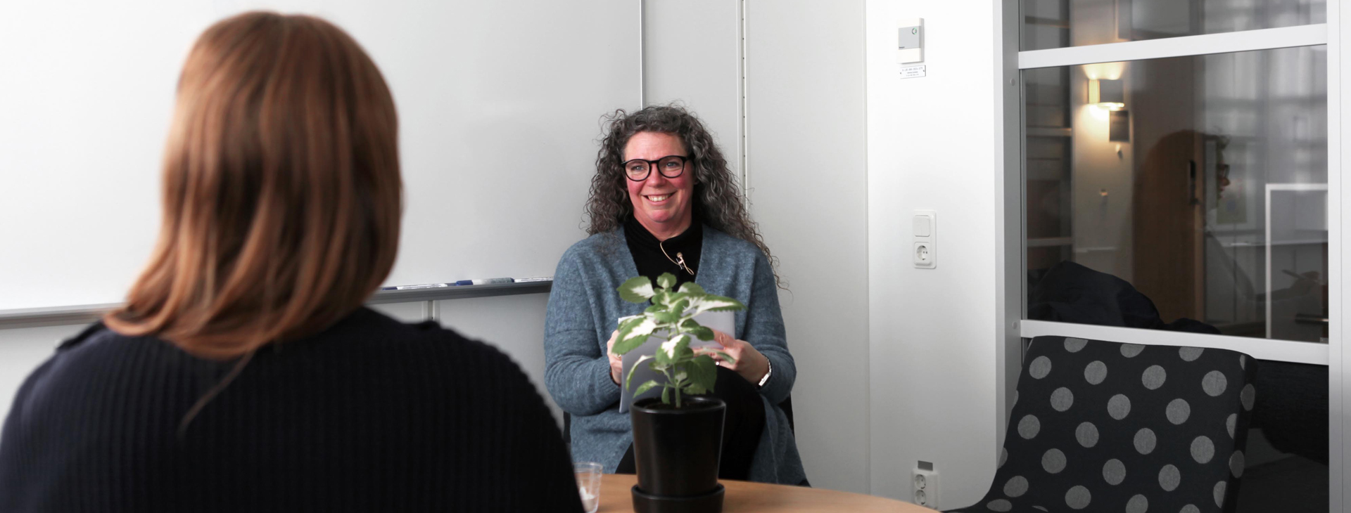 Bild på två kvinnor som sitter i samtal med varandra