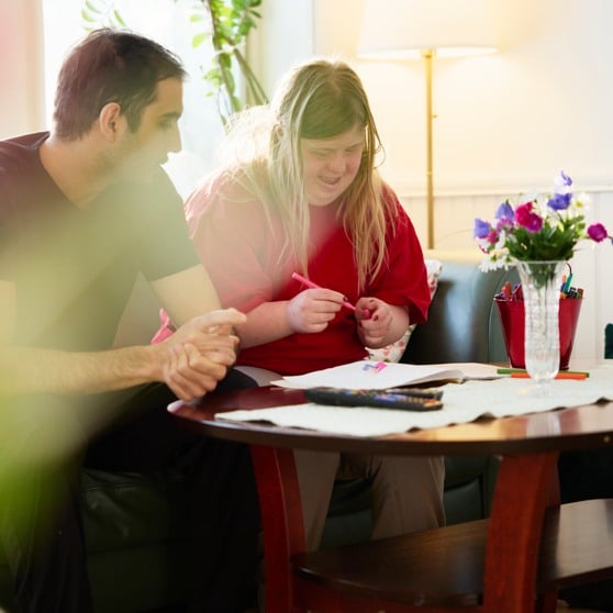 Kille som sitter runt soffbord med kvinna.