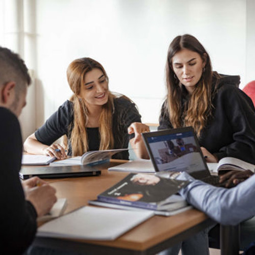 En grupp studenter som sitter vid ett bord.