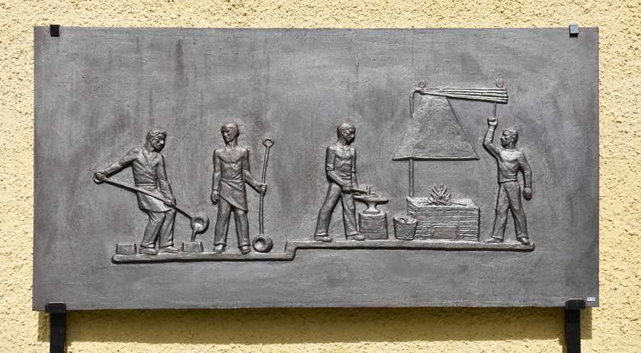 Gjuten metallplatta med motiv från gjuteriet på Ankarsrums bruk.