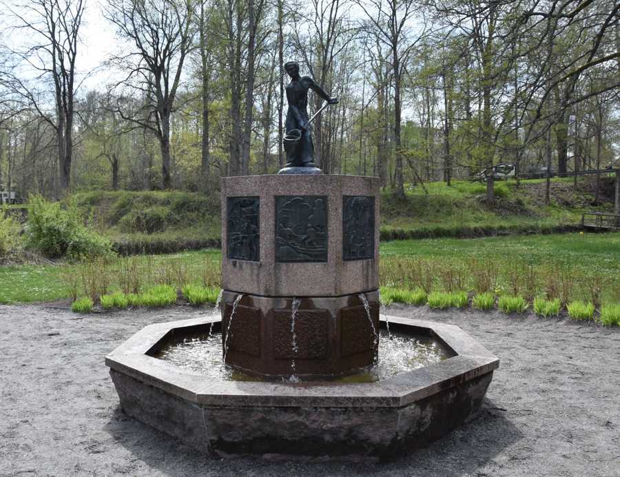 Åttakantig fontän med plattor med motiv från Ankarsrums bruk. Staty föreställande en gjutare vid Ankarsrums bruk. 