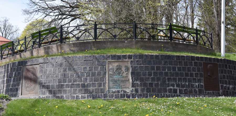 Tre minnestavlor ingjutna i en slaggstensmur.