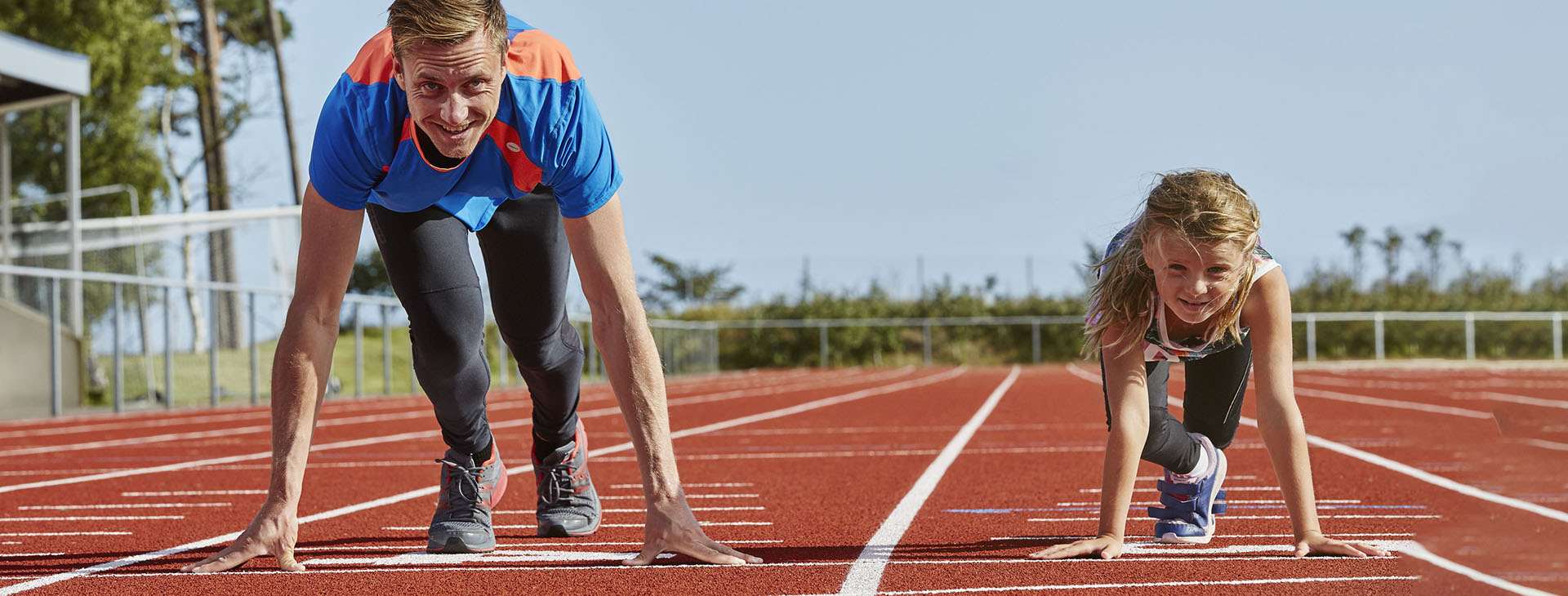 Pappa och dotter tävlar på löparbanan.