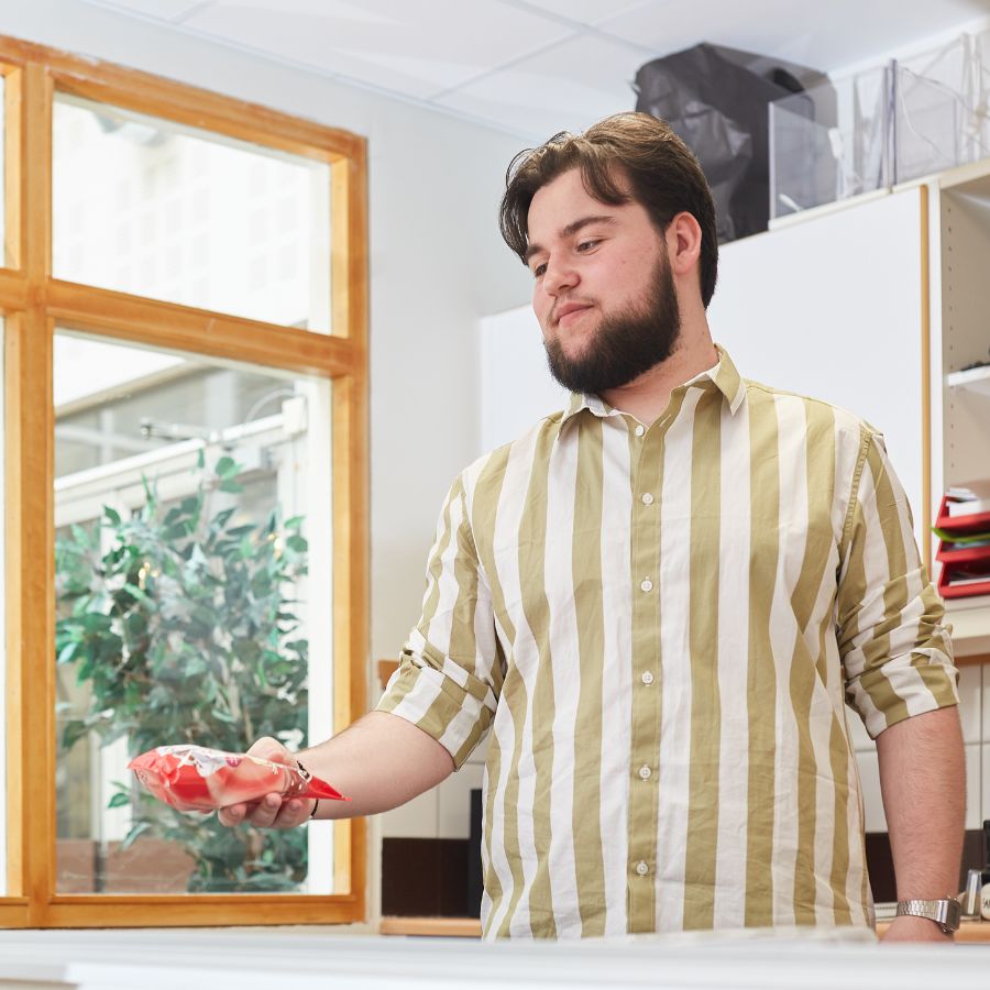 Pojke i randig tröja som säljer varor.