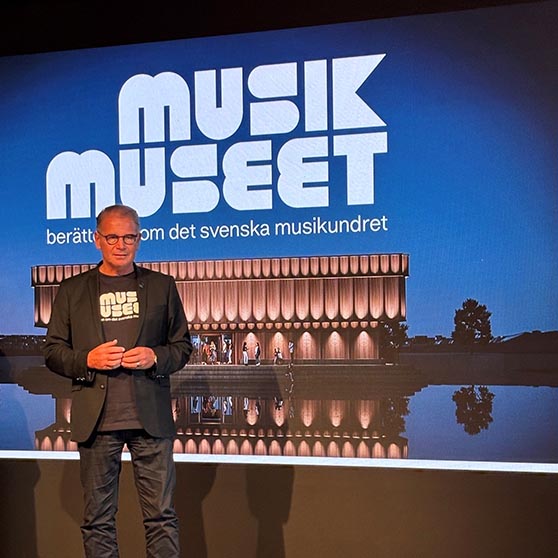 Harald Hjalmarsson framför en bild av musikmuseet. 