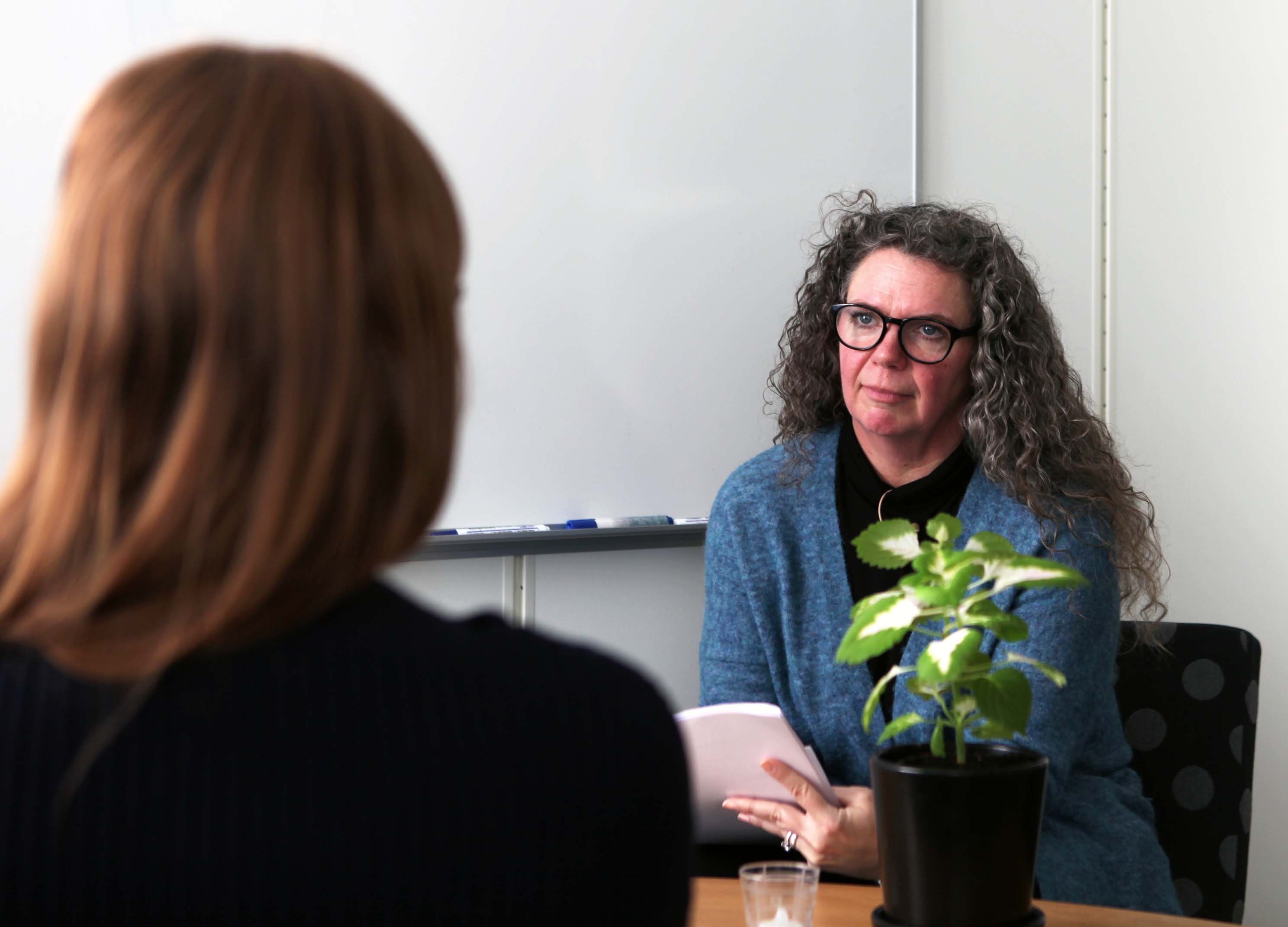 Yrkeskvinna i samtal med ungdom.