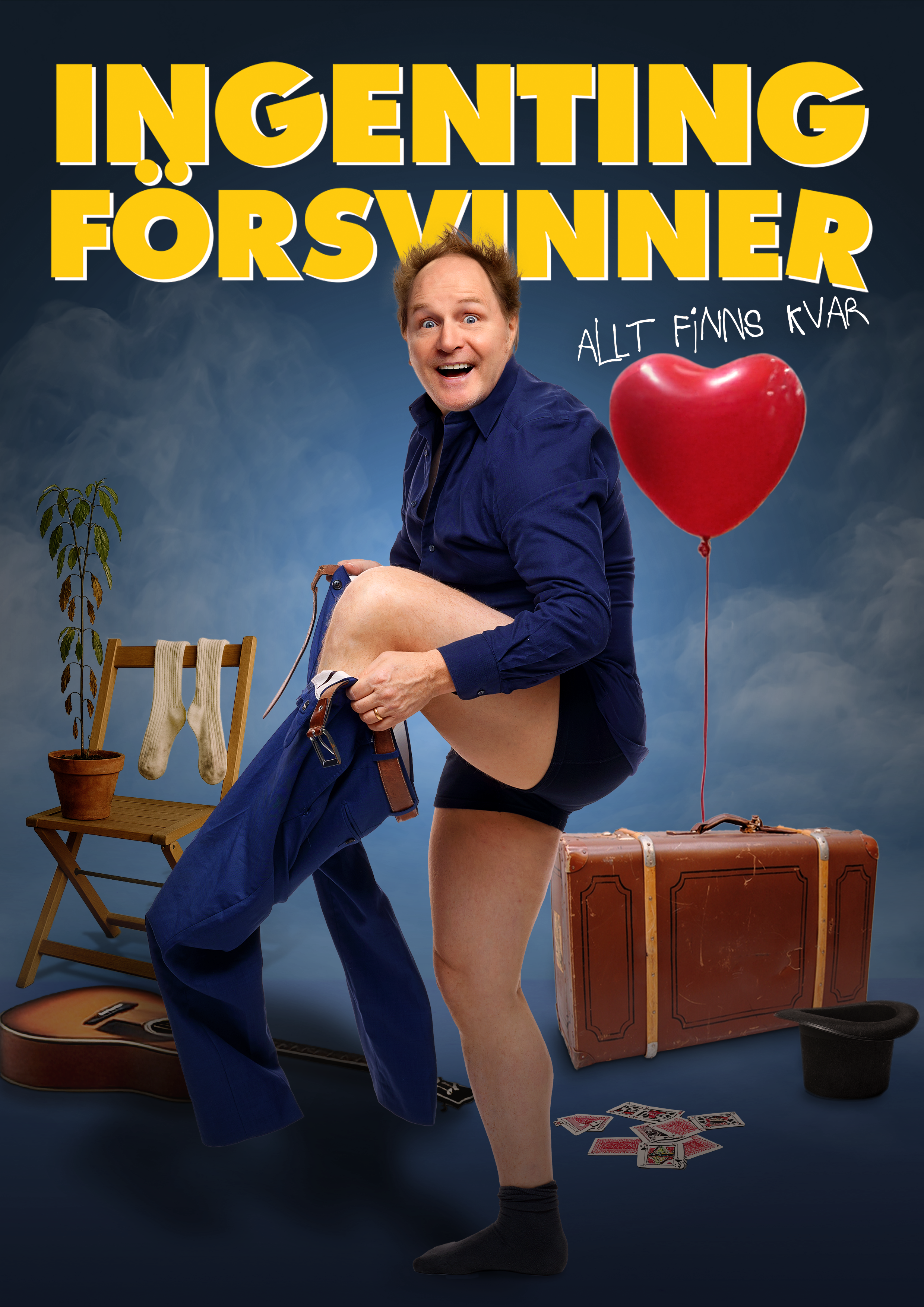 Bildtolkning: Morgan Alling tar på sig ett par byxor. Runt honom finns i bilden en gitarr, en hatt, en kortlek, en krukväxt på en stol med mera.