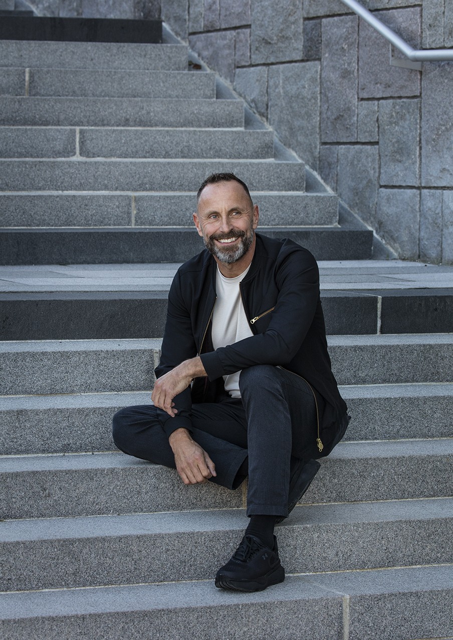 Bildtolkning: En bild på Mattias Sunneborn där han sitter i en trappa utomhus.