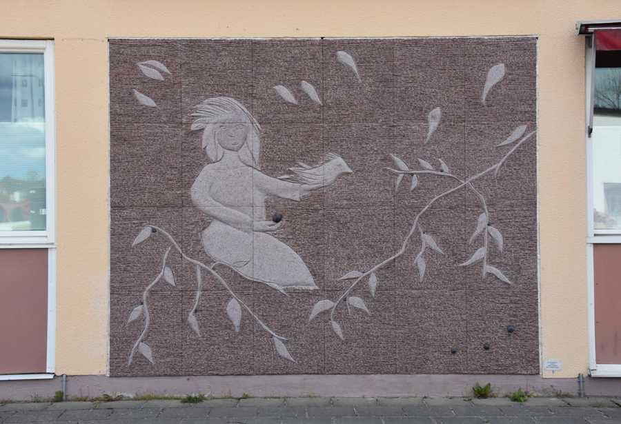 Väggrelief föreställande en sittande kvinna och blåbär.