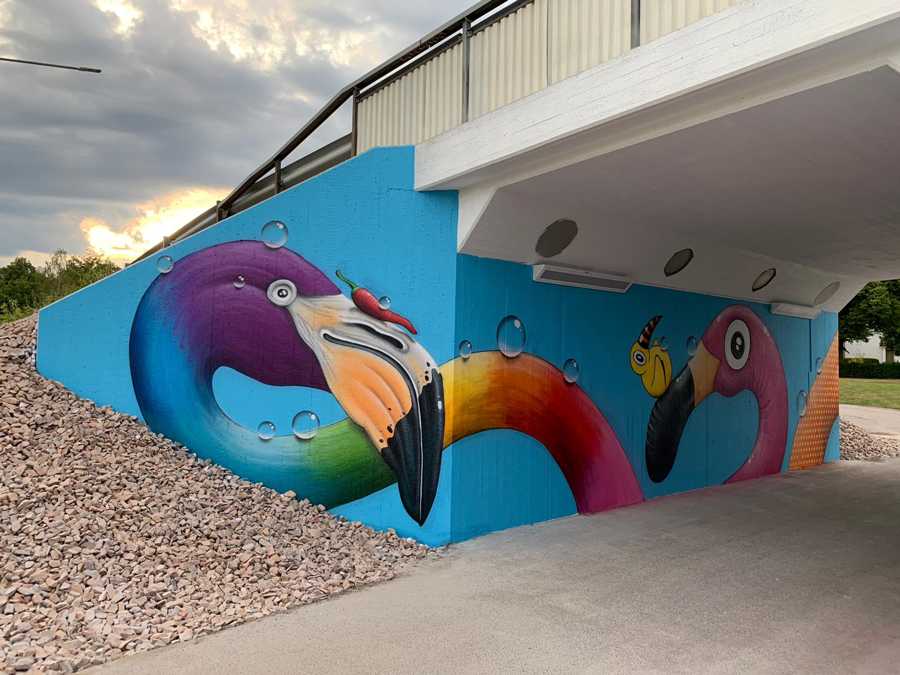 Fantasifåglar i regnbågsfärger mot en blå bakgrund.