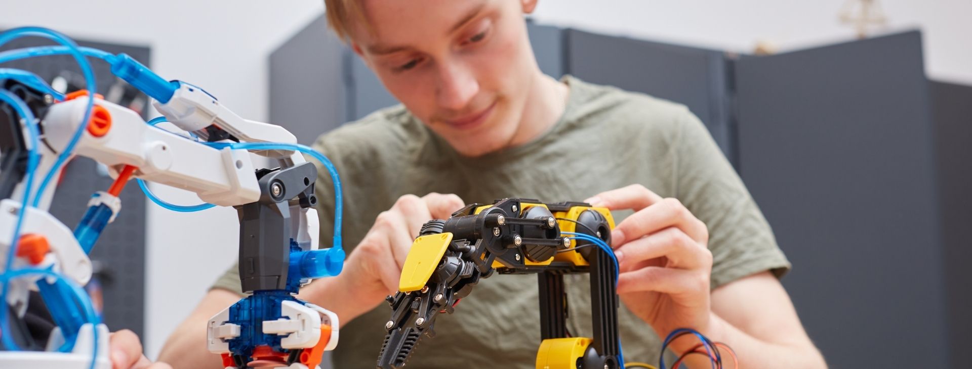 Pojke som står och skruvar på en maskin.