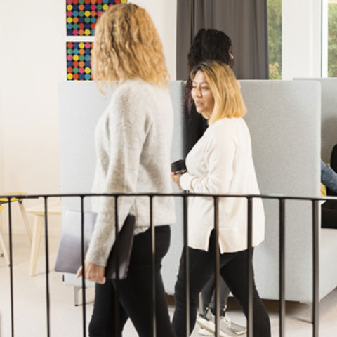 Två personer som sitter och tittar och pekar på en tavla, som har ritade grafer och text.