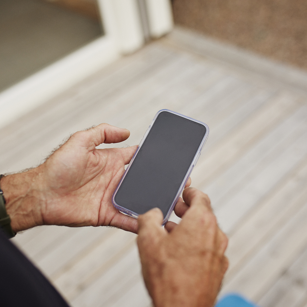 person med mobiltelefon i handen