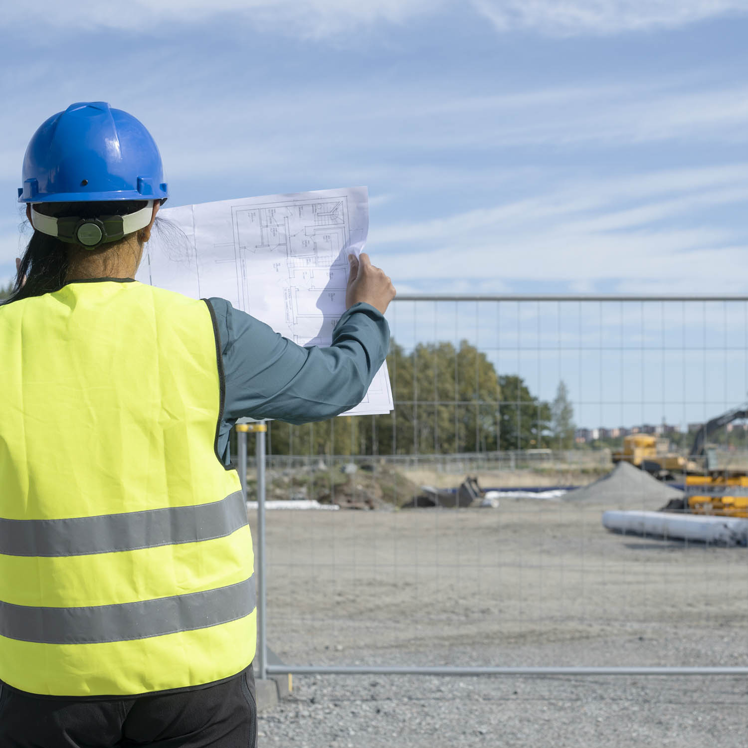 person på byggklar tomt med ritning