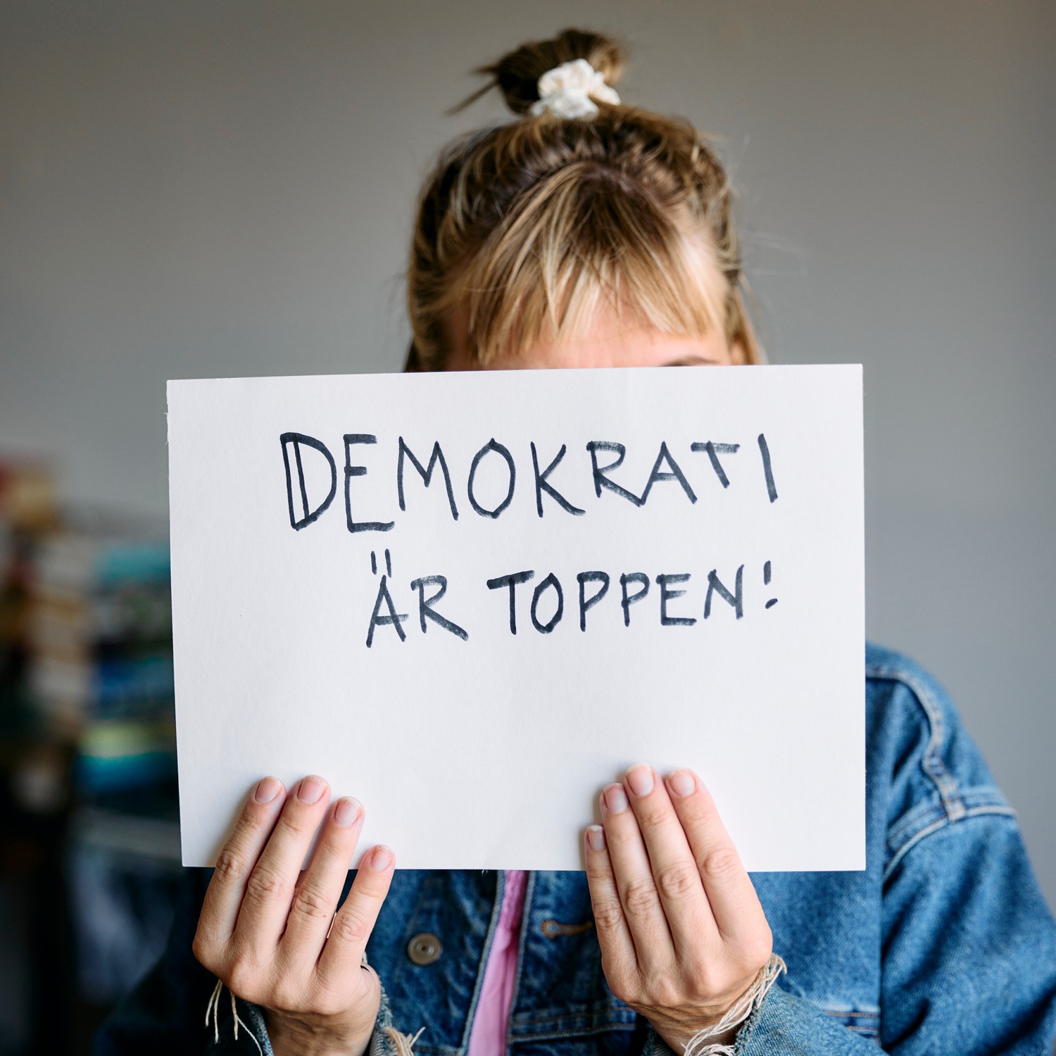 Kvinna håller upp skylt med budskapet "Demokrati är toppen!"
