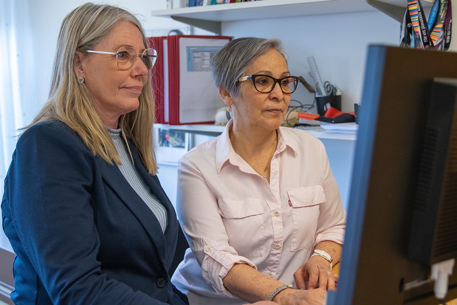 Marie och Ghelen framför datorskärm.