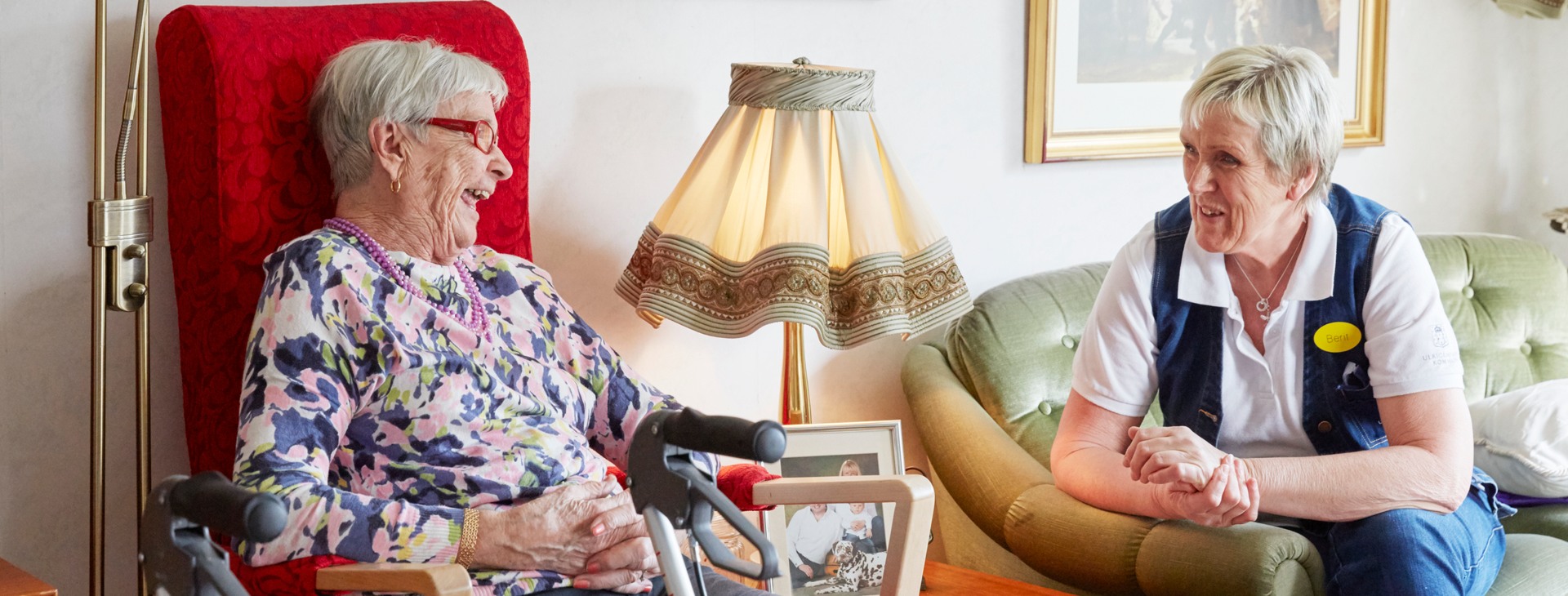  Kvinna i egen lägenhet på äldreboende samtalar med personal.