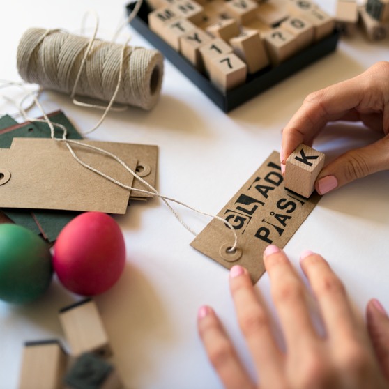 Person som stämplar glad påsk på ett papper. 