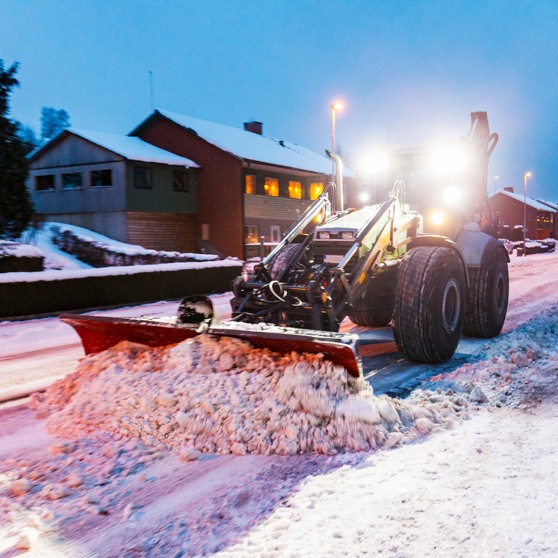 Traktor plogar vägen fri från snö.