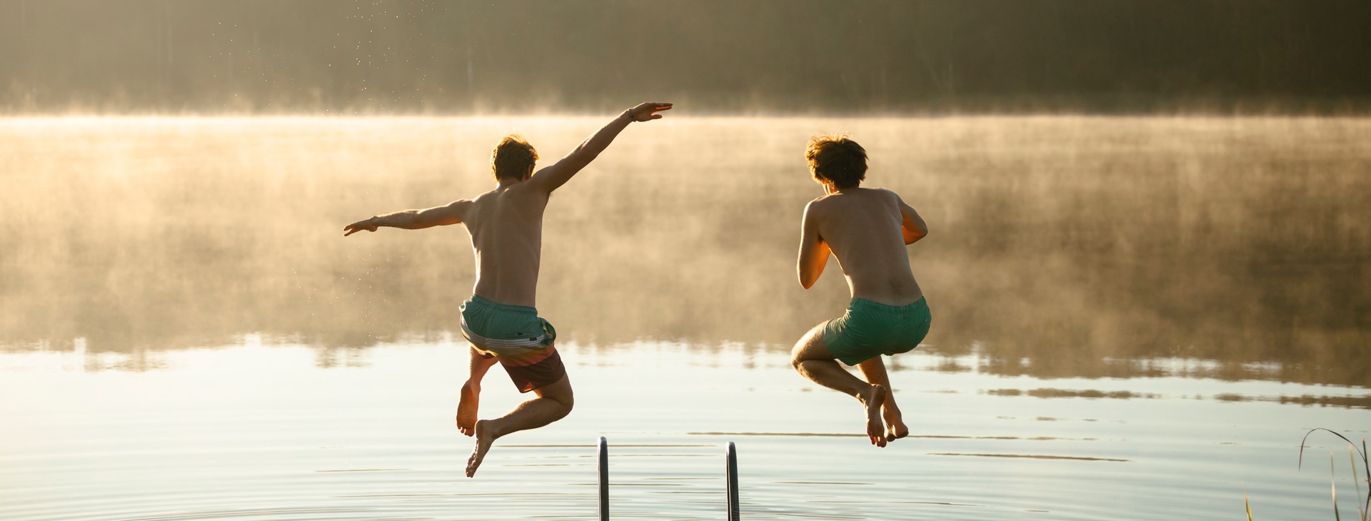 Ungdomar som hoppar från en badbrygga.